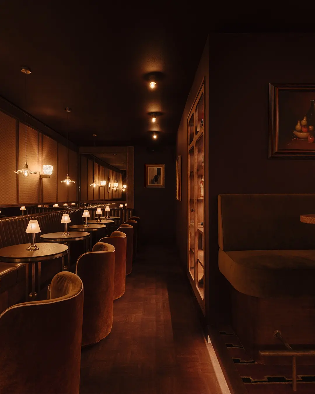 𝐃𝐎𝐎𝐑 𝟕𝟒 . Diepe, gecapitonneerde wandbanken in donker leder, fluweelzachte stoelen en marmeren tafels creëren...